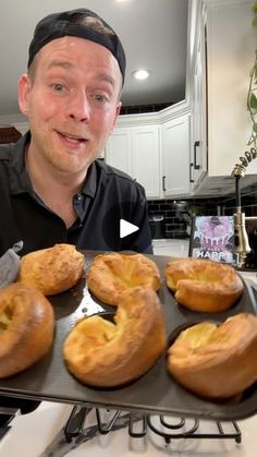 a man holding a tray full of doughnuts