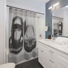 a bathroom with a shower curtain that has two pictures on it and a toilet in the background