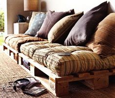 a couch made out of wooden pallets sitting on top of a carpeted floor