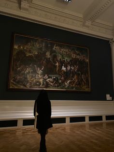 a person standing in front of a large painting on the wall at an art museum