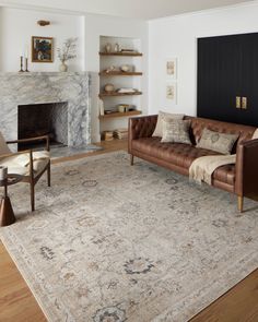 a living room filled with furniture and a fire place in the middle of the room