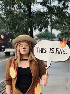 a woman holding a sign that says this is fine