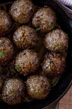 meatballs in a skillet with parsley on the top and green garnish