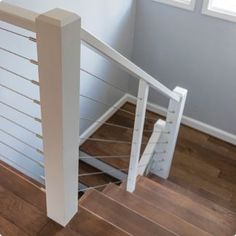 a white stair rail in a house with wood floors