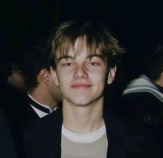 a young man in a black jacket and white t - shirt