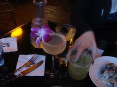 a table topped with plates and glasses filled with food next to drinks on top of each other