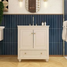 a bathroom with blue tiles and white cabinets