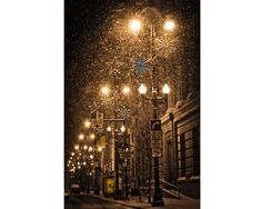 an image of a street at night with lights and snow falling on the ground in front of it