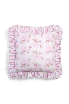 a pink pillow with ruffled edges and floral print on the front, sitting on a white background