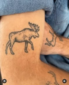 a man with a tattoo on his leg that has a moose and antelope drawn on it