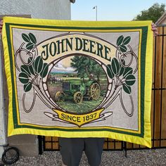 a man holding up a john deere banner