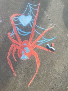 a spider drawn on the ground with crayons next to it and a heart