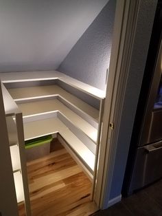 an empty room with built in shelving on the wall and wood flooring underneath