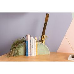 a pair of scissors and some books on a wooden table next to a purple wall