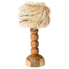 a small wooden table lamp with a white shade on it's top and some straw