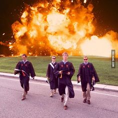 the men are walking down the street with their graduation gowns on fire in the background