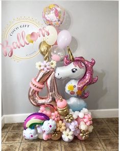 the balloon unicorn is on top of some balloons