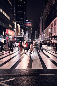 people are crossing the street at night time