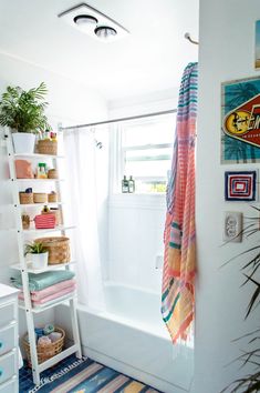 a bathroom with a bathtub, shower curtain and towels on the shelf next to it