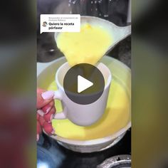 someone is pouring yellow liquid into a cup