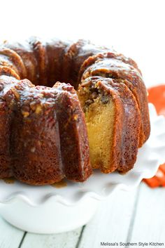 a bundt cake on a white plate with one slice cut out and ready to be eaten