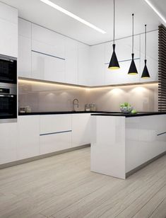 a modern kitchen with white cabinets and black lighting hanging from the ceiling, along with wooden flooring