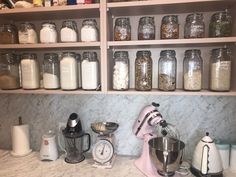 the kitchen counter has many jars and mixers on it