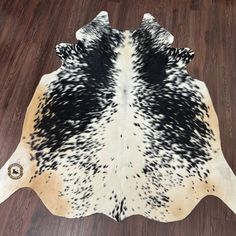 black and white cowhide rug on wooden floor