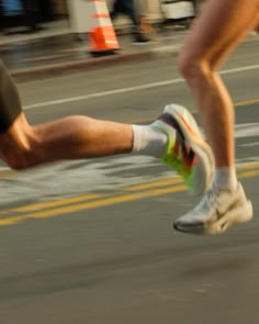 two people are running on the street with their feet in the air and one is wearing socks