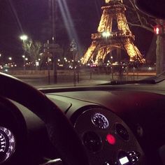 the inside view of a car with the eiffel tower in the background at night