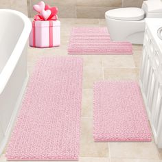 pink bathroom rugs with hearts on them in front of a bathtub and toilet