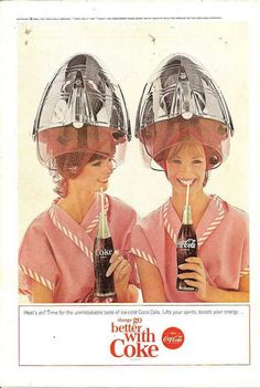 two women wearing helmets and drinking coca cola