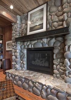 a living room with a stone fireplace and bookshelves