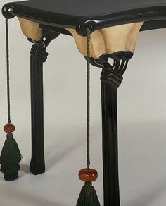 an old fashioned table with tassels hanging from it