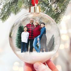 a christmas ornament with an image of two adults and one child on it