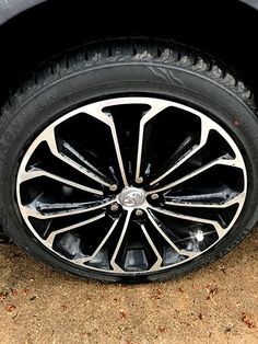 the front wheel of a white car with black spokes