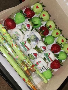 a box filled with lots of green and red strawberries covered in white frosting