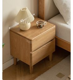 a night stand with a lamp on it next to a bed