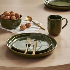 a table with plates, cups and utensils on top of it next to a bowl of cookies