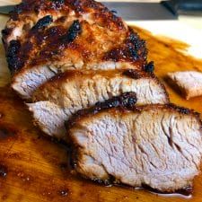 sliced meat sitting on top of a wooden cutting board