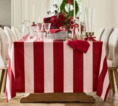 a red and white striped table cloth on a dining room table set for christmas dinner