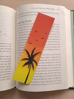 an open book with a piece of paper cut out of it's side and palm tree on top