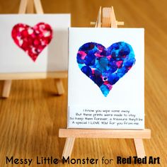 two little cards with hearts on them sitting on a wooden easel next to each other