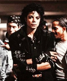 michael jackson is standing with his arms crossed in front of two other men wearing bandanas