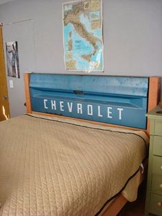 a bed with a wooden head board that says chevrolet on the bottom