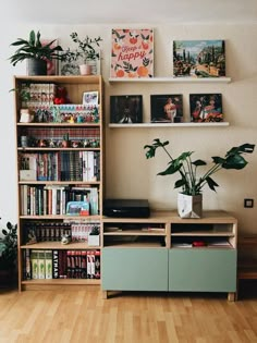 a living room with bookshelves, plants and other things on the shelves in front of it