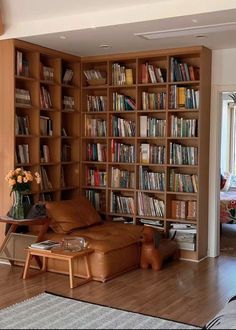 a living room filled with lots of furniture and bookshelves covered in shelves full of books