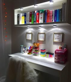 a white desk topped with lots of books and office supplies next to a wall mounted book shelf