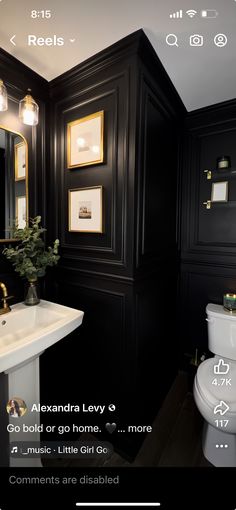 a bathroom with black walls and gold trim on the sink, toilet and bidet