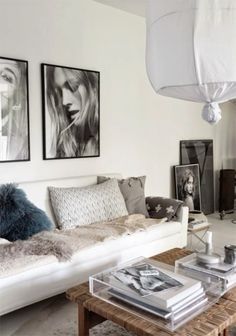 a living room filled with furniture and pictures hanging on the wall above it's coffee table